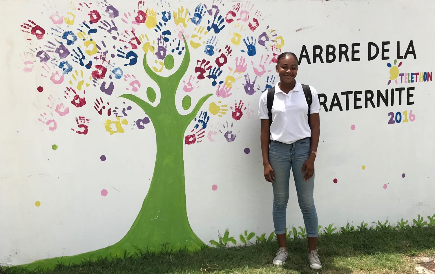 Vanessa REDHEAD devant la fresque représentant l'arbre de la fraternité au collège de QO